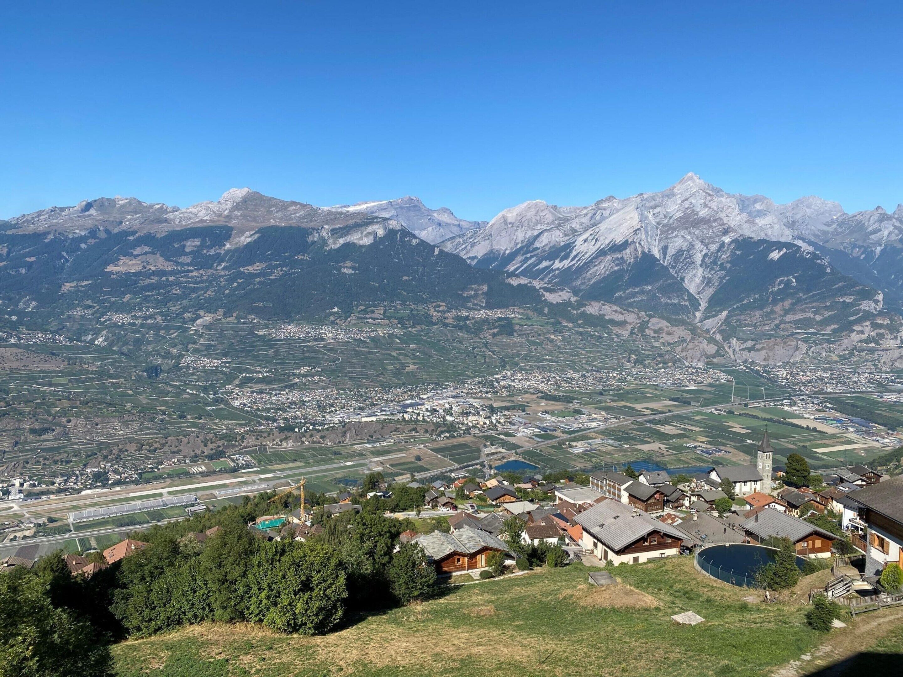 Eine Berglandschaft mit einem Dorf, eingebettet in ein Tal.