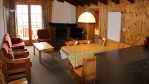 A cozy cabin-style room with a fireplace, wooden furniture, and a dining area. - Gorgeous Apartment Amidst Valleys (Sion)