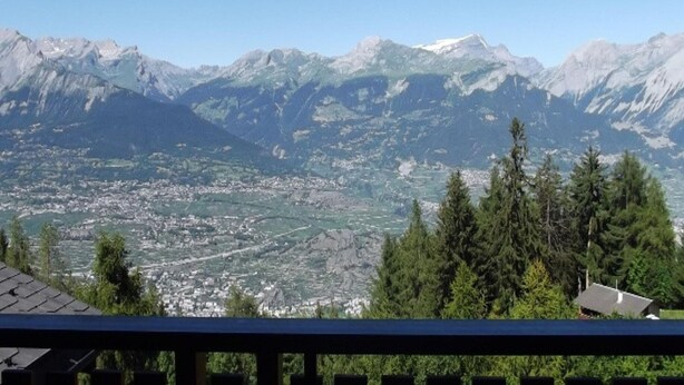 A mountain landscape with a town below. - Gorgeous Apartment Amidst Valleys (Sion)