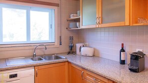 A kitchen with a double sink, a toaster, a wine bottle, and a coffee machine. - Bleu Soleil By Ericeira Property (Mafra)
