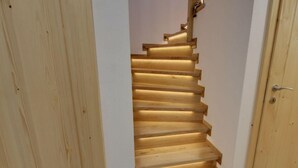 A wooden staircase with a handrail and a door at the bottom. - Beautiful Pondside Villa (Korenov)