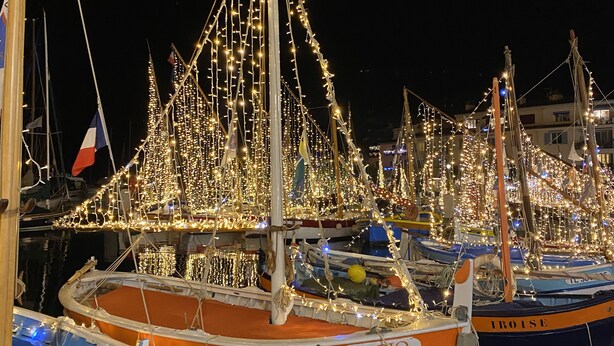 A marina at night with boats decorated with lights.