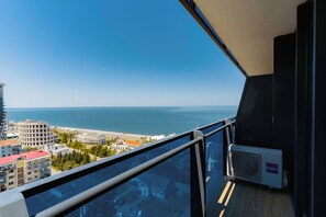 A balcony with a view of the sea and buildings.