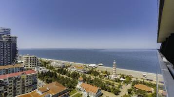A coastal cityscape with high-rise buildings, a beach, and a prominent tower.