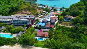 A coastal resort with multiple buildings, a swimming pool, and a view of the sea.