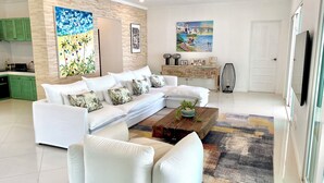 A modern living room with a sectional sofa, a coffee table, and a colorful rug.