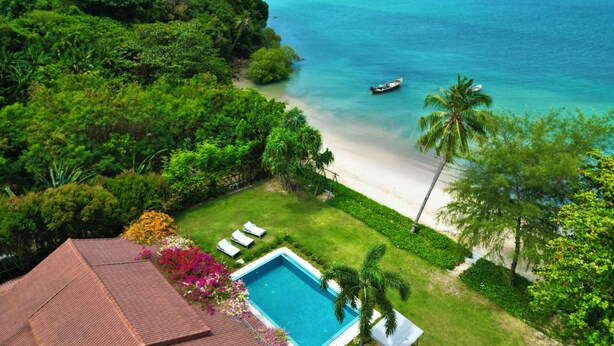 A tropical resort with a pool, beach, and ocean view.