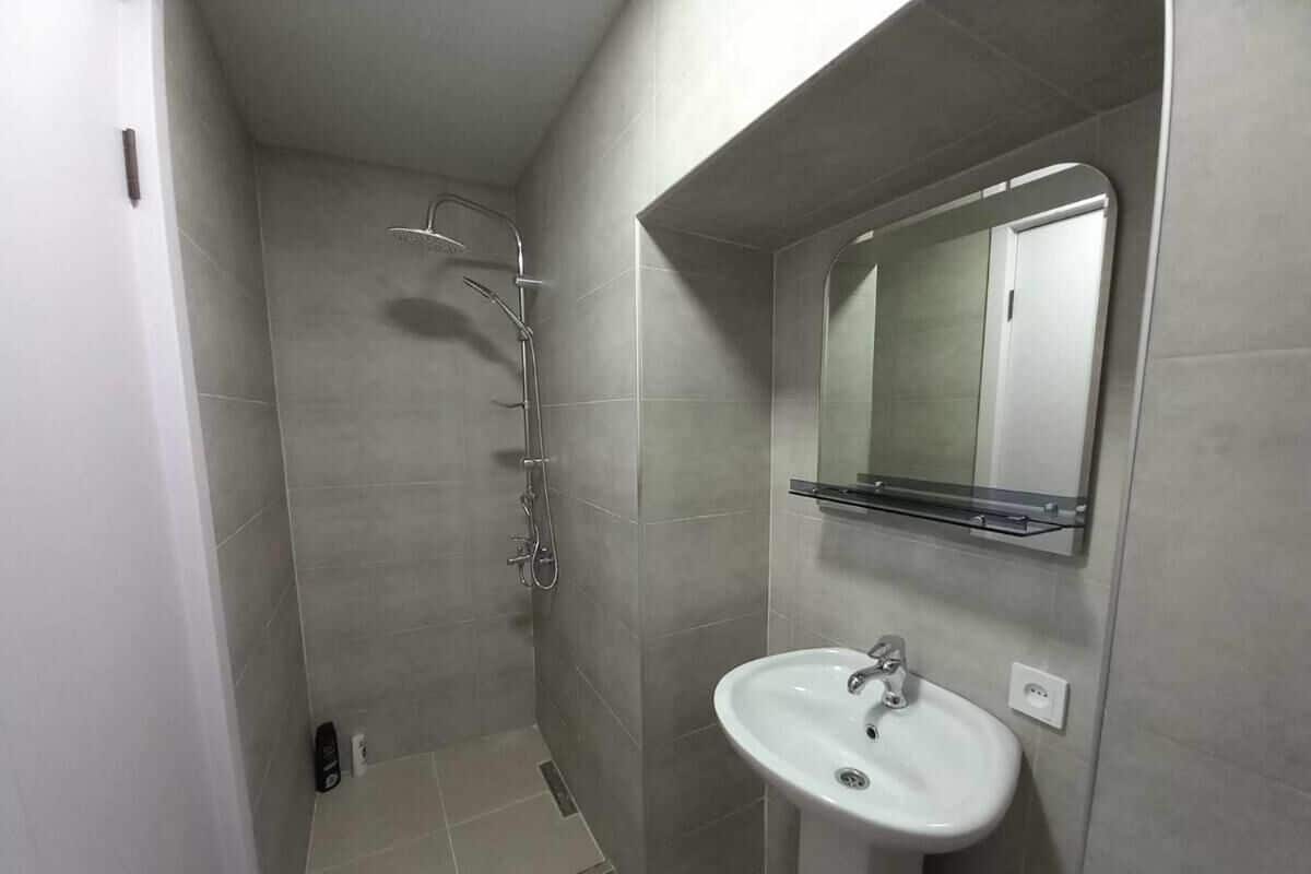 A bathroom with a shower, a sink, and a mirror.