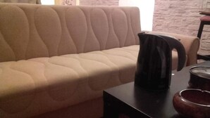 A beige sofa with a black coffee maker on a black table. - Egli's boutique (Lavreotiki)