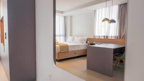 A modern bedroom with a bed, bedside table, and a desk area. - Egli's boutique (Lavreotiki)