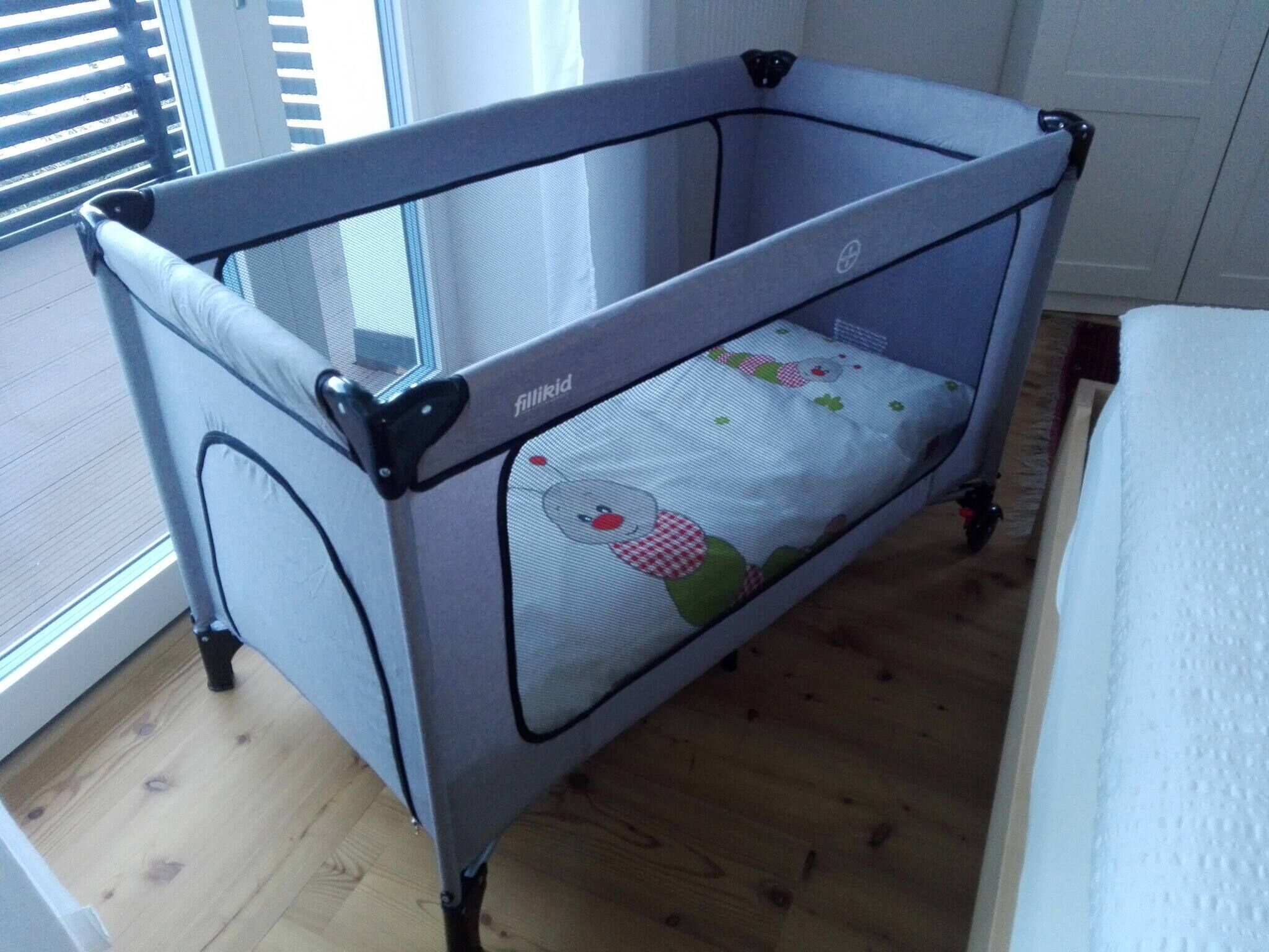 Un berceau pour bébé doté d’un dessus en tissu à mailles et d’un matelas orné d’un motif représentant un personnage de dessin animé.