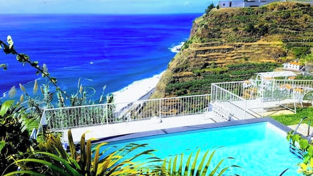 A pool with a view of the ocean and a hillside. - VIEWPOINT HOUSE (Calheta)