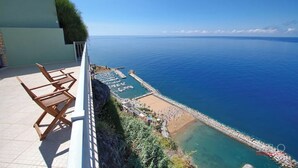 A terrace with a view of the sea, a pool, and outdoor seating. - VIEWPOINT HOUSE (Calheta)