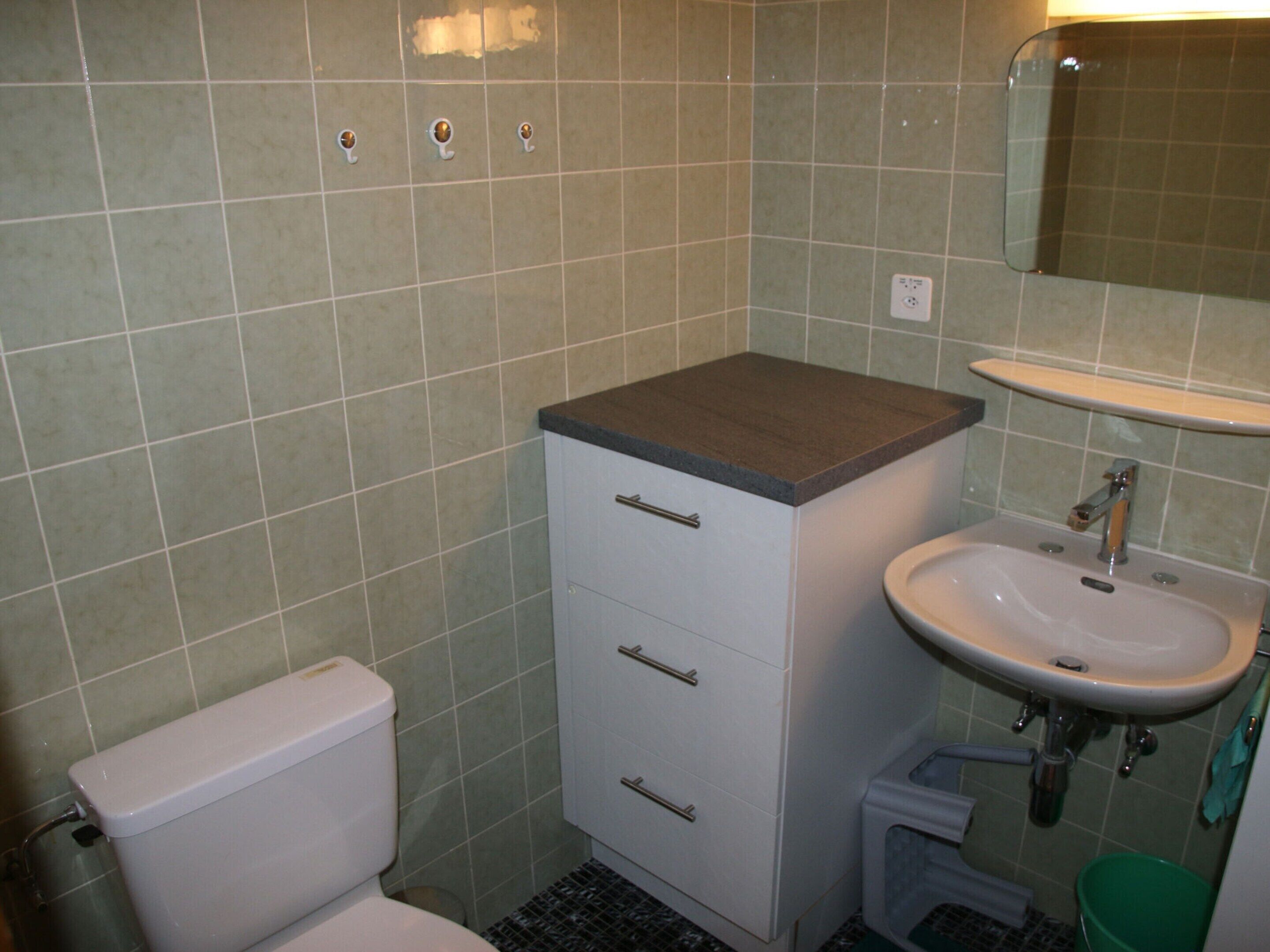 Ein Badezimmer mit Toilette, Waschbecken und einem Schrank.