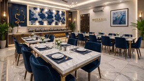 A restaurant with a modern interior, marble flooring, and blue chairs. - HOTEL VENUE Delhi Airport (New Delhi)