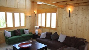A wooden interior with two sofas, a coffee table, and a lamp. - Chalet Nestled in Mountains and Garden (Nendaz)