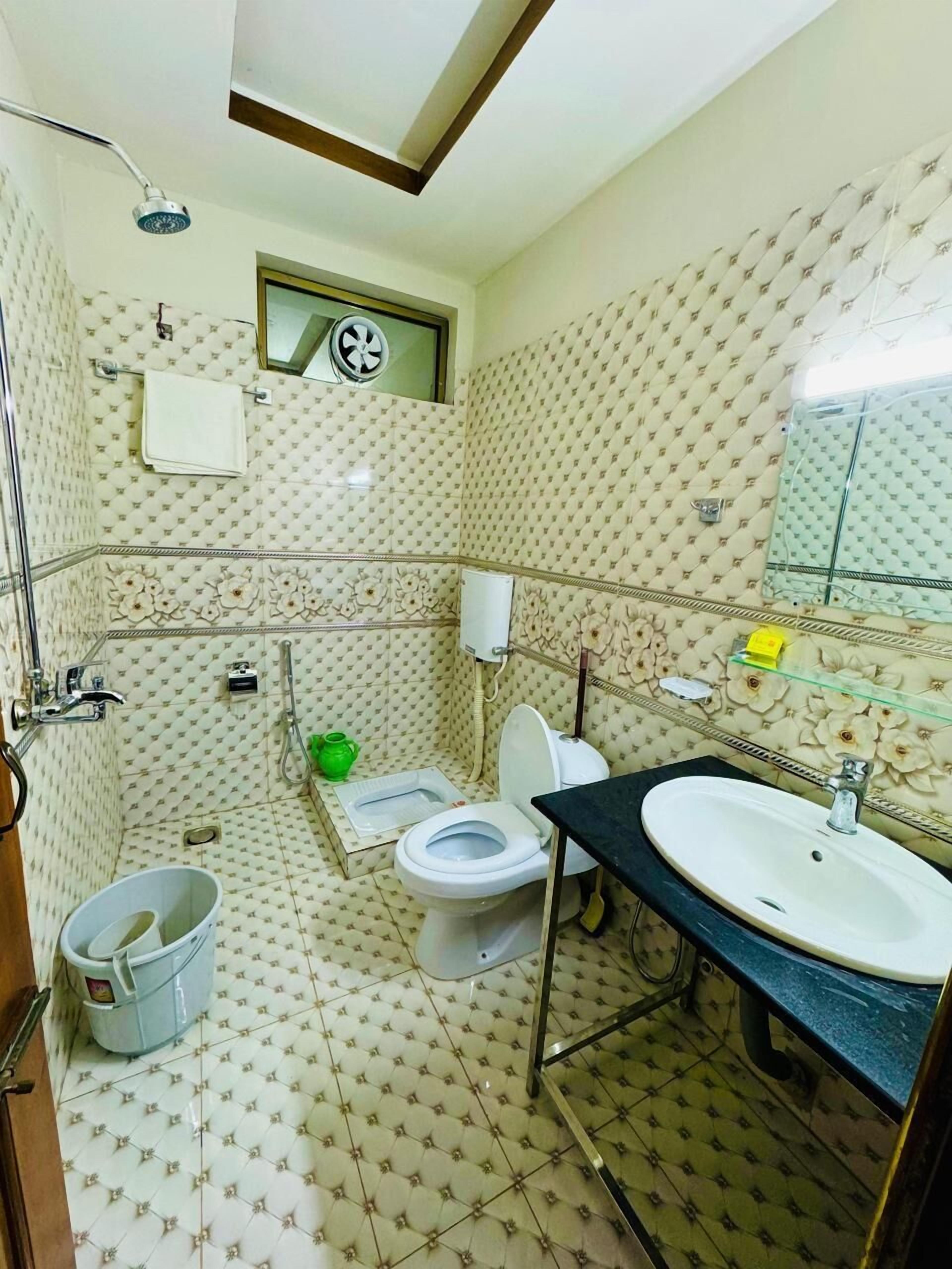 Un baño con inodoro, bidé, lavabo y ducha.