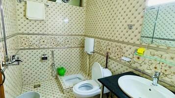 Un baño con inodoro, bidé, lavabo y ducha.