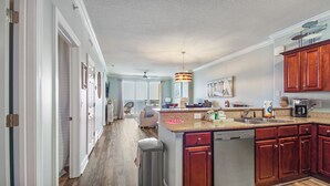 A spacious kitchen with wooden cabinets, a granite countertop, and a built-in dishwasher.