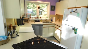 A compact kitchen with a stove, microwave, sink, and refrigerator. - Bright and cozy private cottage (CS0037) (Wellfleet)