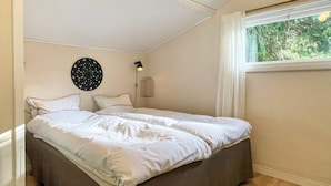 Una camera da letto con un letto, una lampada a parete, una finestra con tende e un decoro circolare al muro.