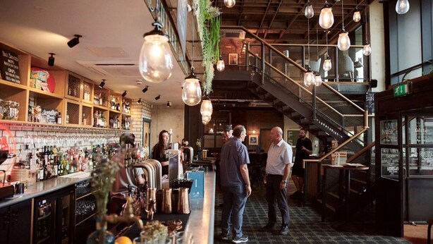 A bar area with a staircase, shelves with bottles, and hanging light fixtures. - -15% LUX Riverside Duplex Masionette By LCY/ExCeL I 25min to Tower of London (London)