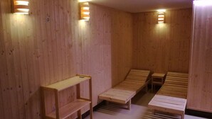 A sauna room with wooden benches and shelves, and wall-mounted lights. - Beautiful Villa With Spacious Rooms (Lešany)