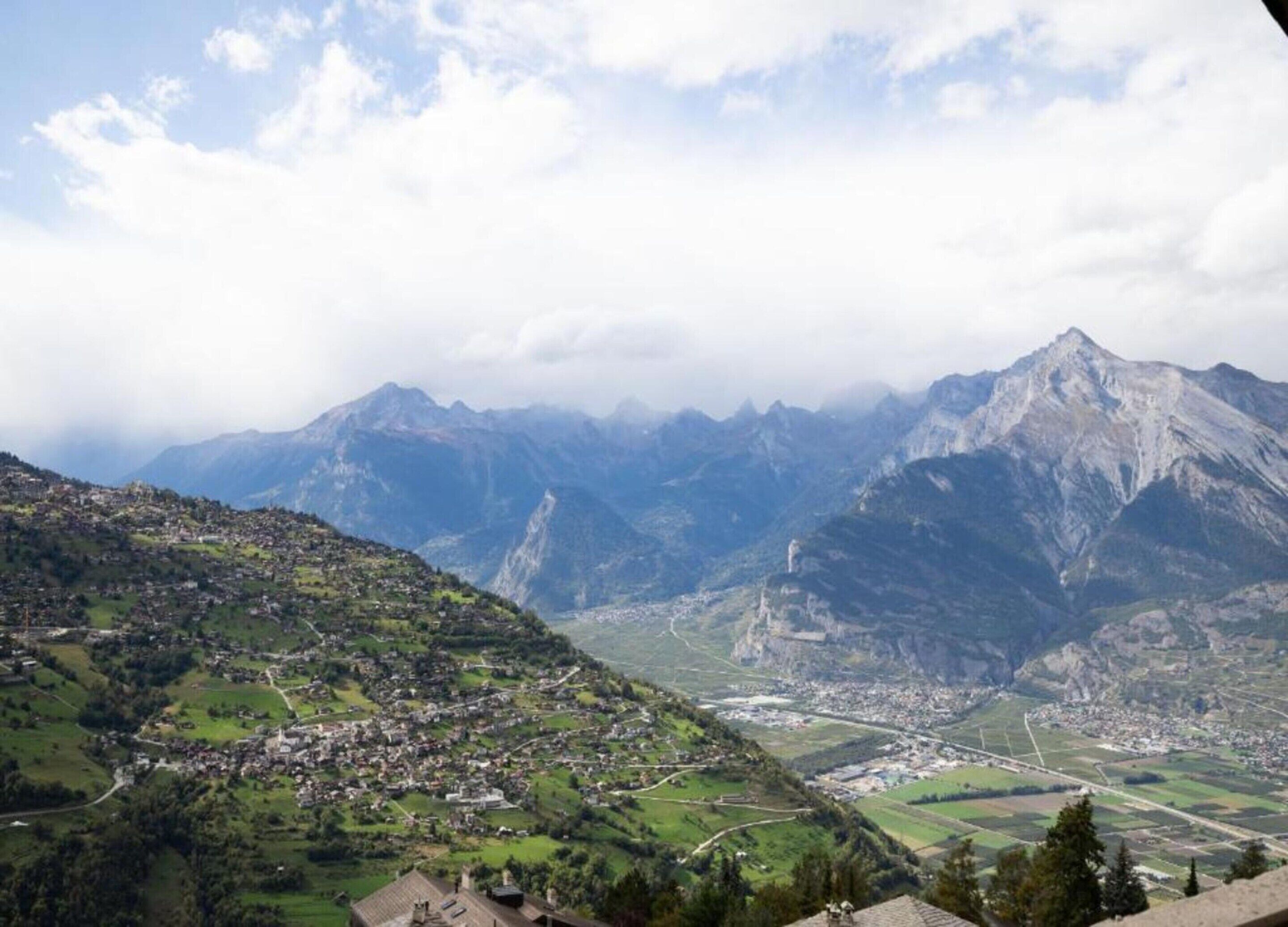 Un paysage montagneux avec une ville située dans une vallée.