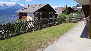 A chalet-style building with a balcony, surrounded by a wooden fence, overlooking a mountainous landscape. - Stunning Apartment With Mountain Views (Veysonnaz)
