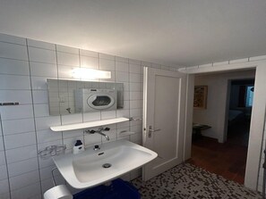 A bathroom with a white sink, a mirror, a washing machine, and a tiled floor. - Cache-cache Mountain & Quiet Chalet 10 Pers (Nendaz)