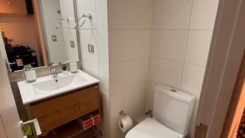 Un baño con lavamanos, espejo y retrete.