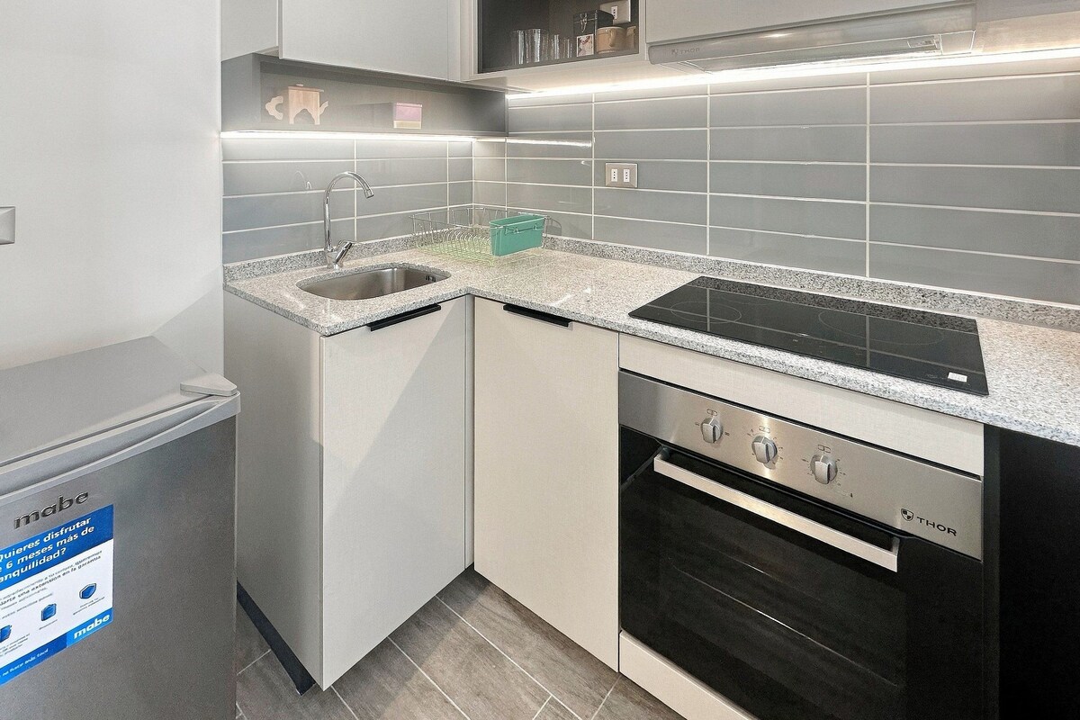 Une cuisine moderne équipée d’un lave-vaisselle encastré, d’une cuisinière et d’un évier.