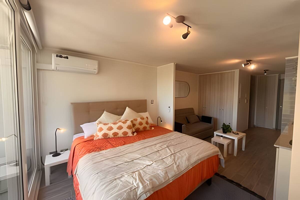 Een moderne hotelkamer met een groot bed, een bureau en een klein tafeltje.