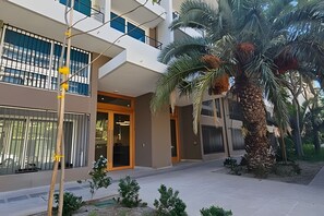 A modern building with a flat roof, large windows, and a central entrance.