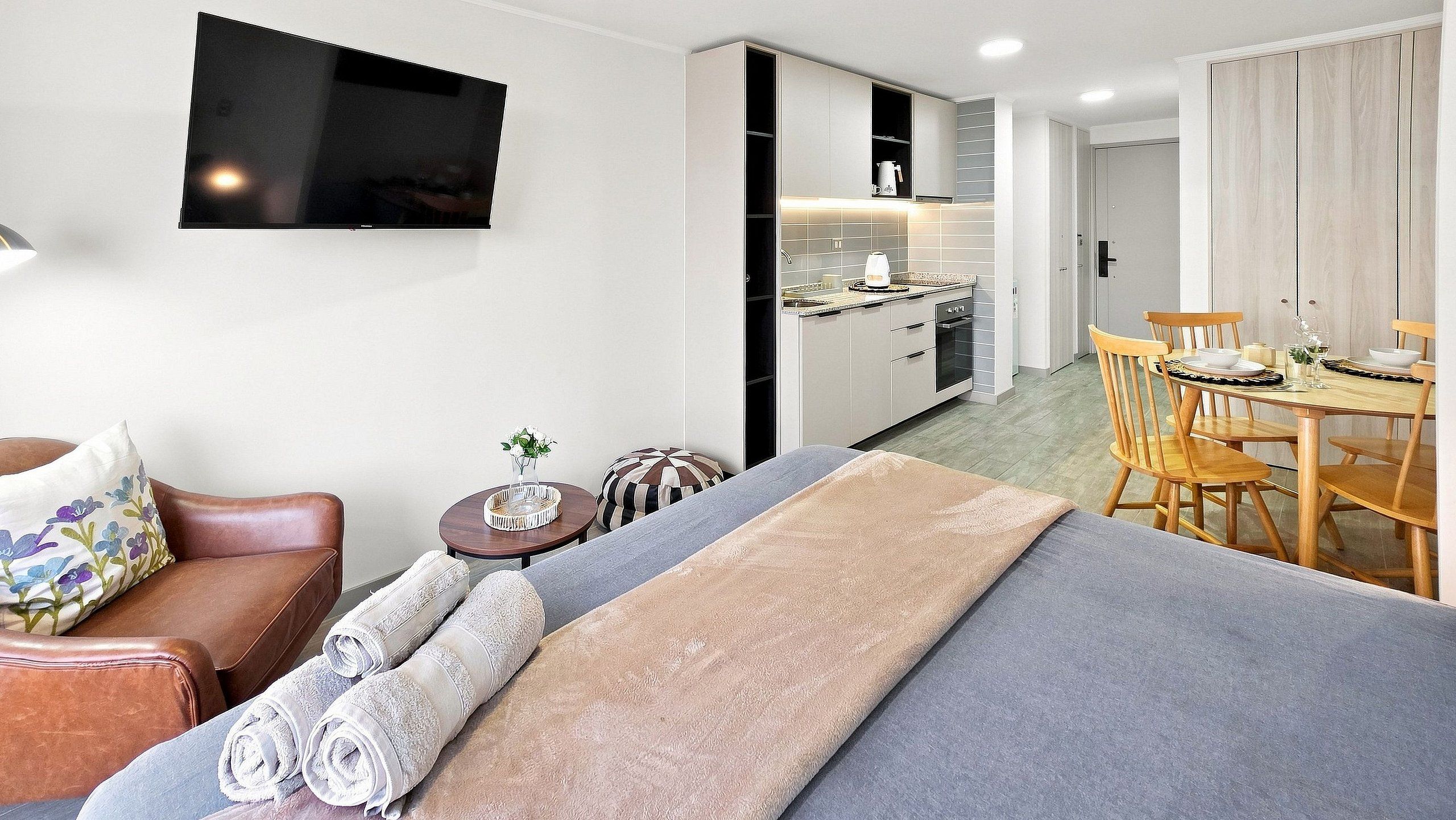 Un salon moderne avec un canapé, une table basse et un téléviseur fixé au mur.