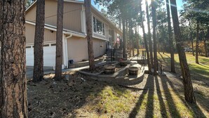 A single-story house with a garage, surrounded by trees and a well-maintained lawn. - Spacious 4-bed house in the woods of beautiful Monument by the Air Force Academy (Monument)