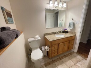 Een badkamer met toilet, wastafel en opbergmeubel.