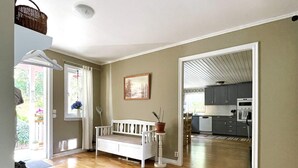 A spacious living area with a wooden floor, a white sofa, a dining table, and a kitchen in the background. - 6 Person Holiday Home in Valdermarsvik (Gryt)