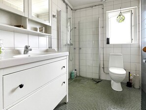 A bathroom with a white vanity, a toilet, and a shower enclosure. - 6 Person Holiday Home in Valdermarsvik (Gryt)