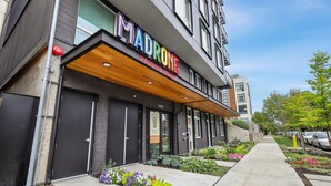 A modern building with a sign reading "MADRONE PASSIVE HOUSE" and a number "1419" on the facade.