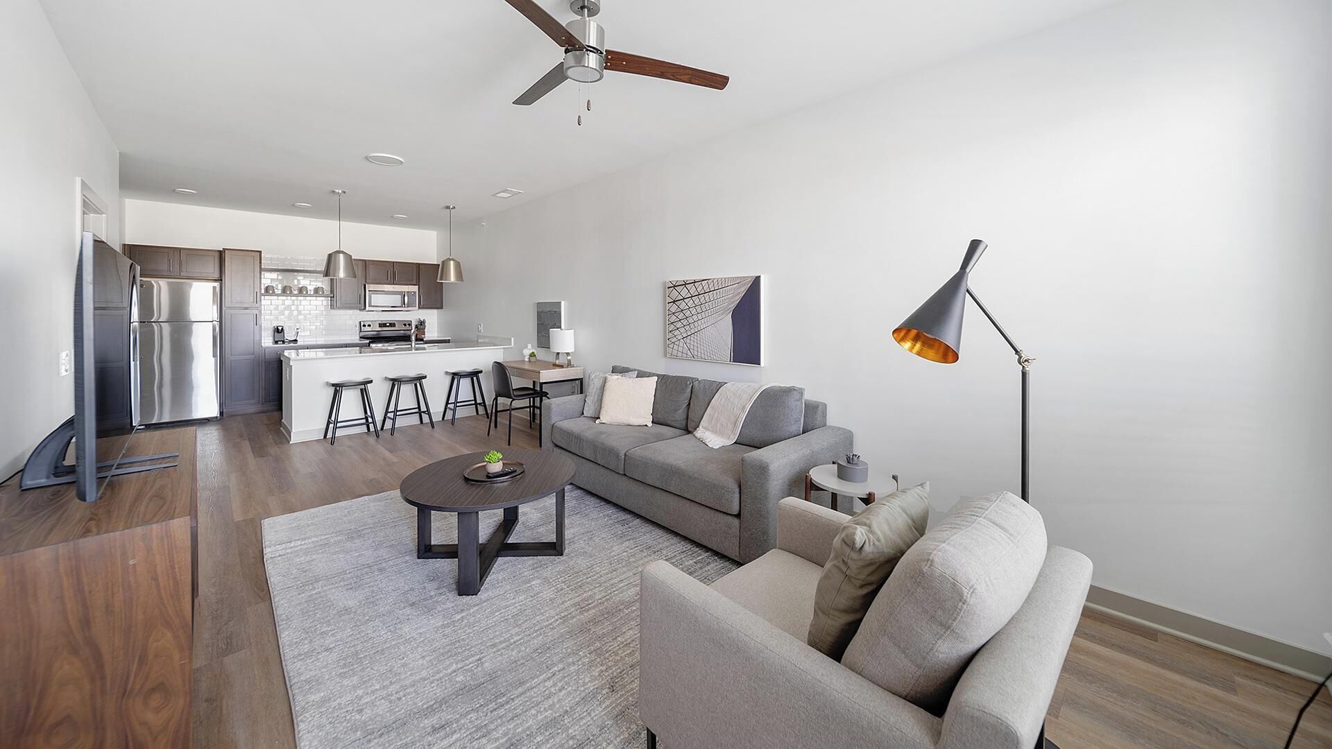 A modern apartment with a kitchen, dining area, and living room.