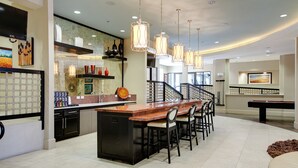 A modern kitchen with a central island, bar seating, and pendant lighting. - Landing | Stunning Studio, Courtyard, Pool (Dallas)