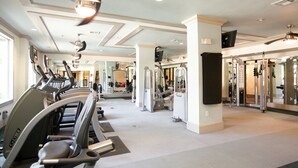 Ein Fitnessstudio mit Laufbändern, Kraftgeräten und Spiegeln.