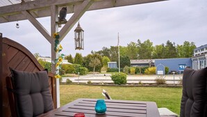A wooden table with two candles and a lantern under a wooden pergola. - 2 Person Holiday Home in Nexo (Nexø)