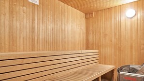 A sauna room with wooden benches and a sauna machine. - 2 Person Holiday Home in Nexo (Nexø)