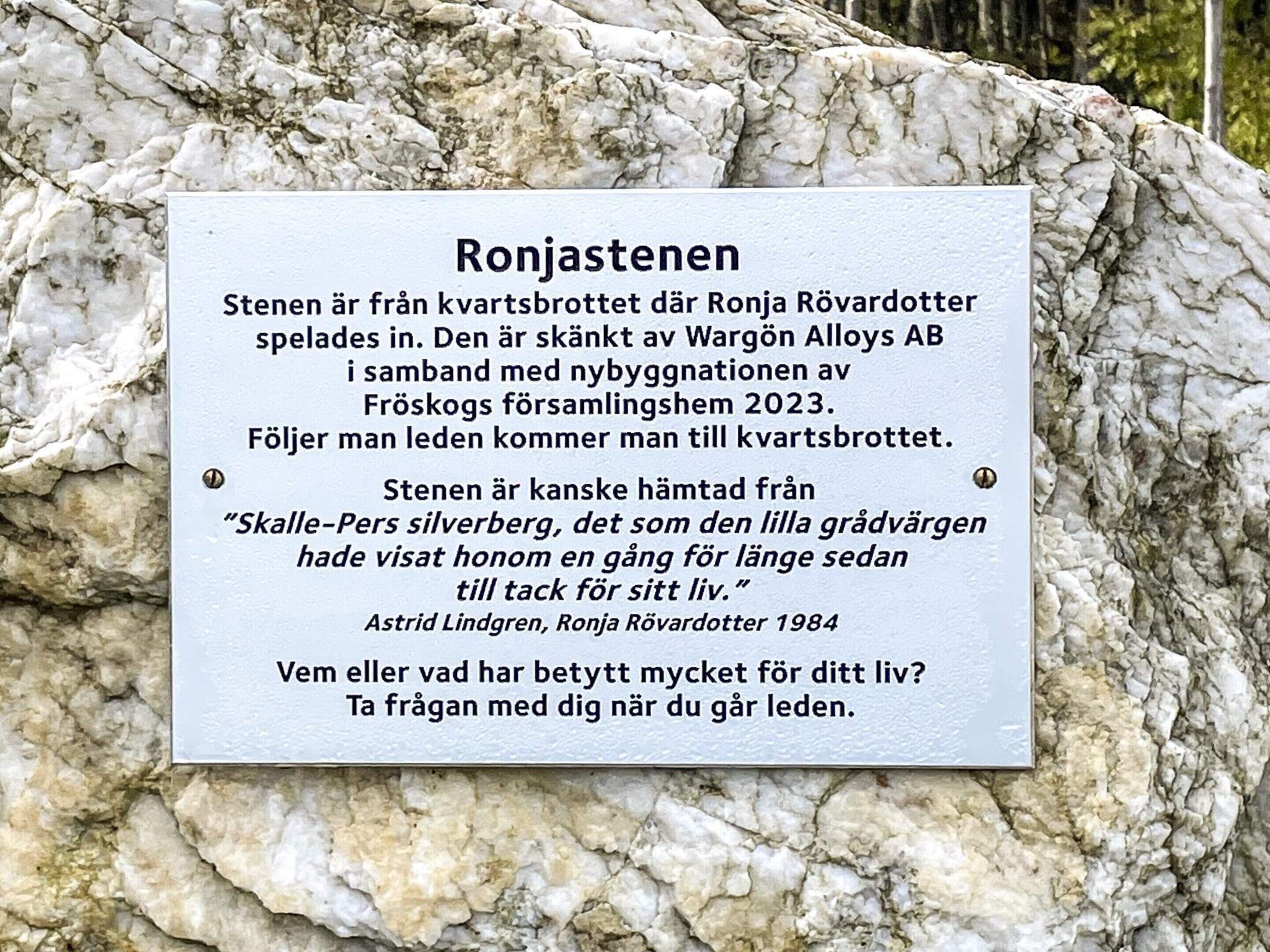 A sign with text in Swedish, mounted on a rock.