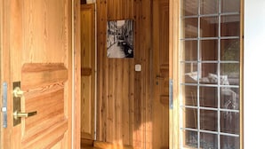 A wooden interior with a door, a glass window, and a framed picture on the wall. - 4 Star Holiday Home in Fengersfors (Fengersfors)