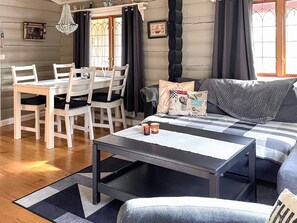 Un salon confortable avec un canapé, une table basse et un coin repas comprenant des chaises et une table.