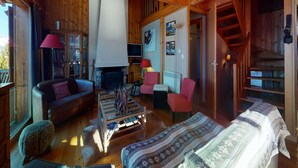 A cozy wooden cabin interior with a fireplace, a sofa, a chair, and a bed. - Chalet in the Heart of Valley With Balcony (Nendaz)
