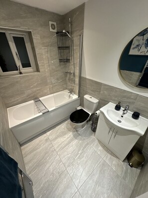 A modern bathroom with a bathtub, toilet, and sink.